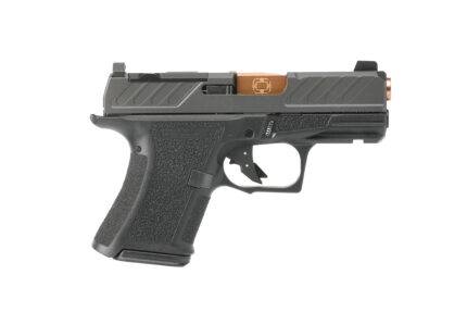 Black compact handgun with copper-colored accents