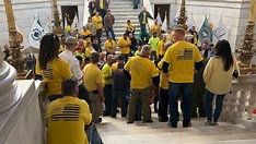 group of people protesting outside statehouse building