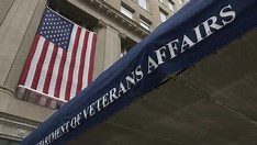 A veteran proudly displays a handgun while standing in front of an American flag