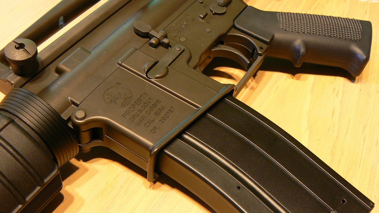 A semi-automatic AR-15 rifle resting on a table at a shooting range