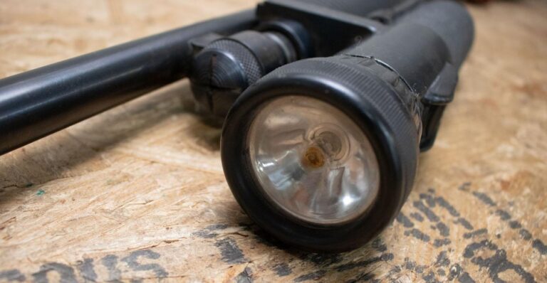 12-gauge pump-action shotgun equipped with tactical light mounted on rail