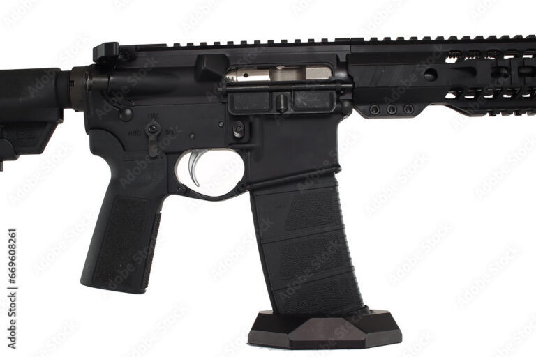A modern AR-15 rifle with optics on a wooden workbench