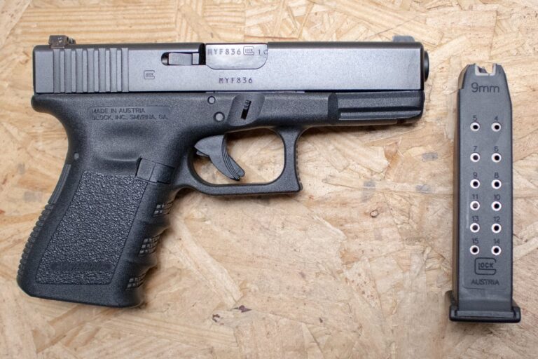 A Glock 19 semi-automatic 9mm pistol resting on a wooden surface