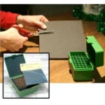 MTM ammunition box foam liner, dark gray sheet being cut beside green ammunition boxes