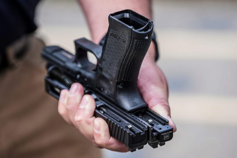 A close-up of a Glock-style handgun representing the legal debate