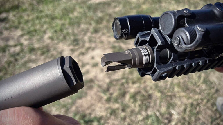 A modern rifle equipped with a professional titanium suppressor attached to the muzzle