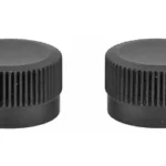 TRIJICON ACOG ADJ CAPS two black round ribbed adjustment caps, angled top view