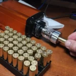 Lyman Brass-Smith Case Trim Xpress, black trimmer in use beside rows of brass cases