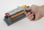 Smith's 6-inch Three Stone Sharpening System with knife held against orange stone