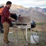 Camp Chef Leg Kit for Mountaineer, silver legs supporting an outdoor stove