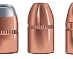 Speer TMJ copper-coloured handgun bullets, three upright with flat noses and grooved jackets