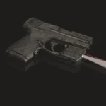 Crimson Trace Laserguard Pro, black unit mounted on pistol with red laser beam projecting right