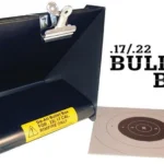 Do-All Outdoors Bullet Box, blue metal trap with top clips and paper target beside it