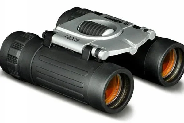 Konus BASIC compact binocular black and silver, angled front view with orange-tinted lenses