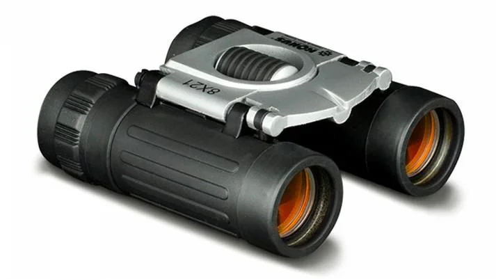 primary-36890 Konus BASIC compact binocular black and silver, angled front view with orange-tinted lenses