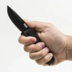SOG Terminus Bowie folding knife, black blade and handle, open in a right hand