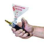Lee New Auto Prime hand priming tool held in one hand with clear primer tray and brass case