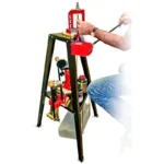 Lee Press Reloading Stand, black tripod stand with red press mounted and operator seated beside it