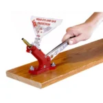 Lee Auto Bench Prime, red bench-mounted tool with silver handle held by a hand