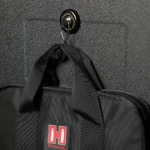 SnapSafe Magnetic Hooks, round black hook mounted on a textured surface and holding a bag