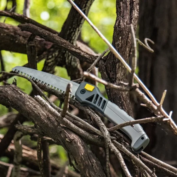 Gsm Hawk Wood Saw, grey folding saw positioned on a tree branch, right-side view