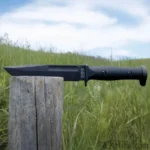 KA-BAR Knives KBAR SLABBY FIXED black knife in right-side view on a wooden post