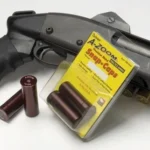 A-Zoom AZOOM SNAP CAPS 20 GAUGE 2/PK two maroon snap caps and yellow package beside a black shotgun
