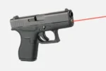 LaserMax Guide Rod Laser for Glock 42, installed in black handgun with red laser beam visible