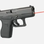LaserMax Guide Rod Laser for Glock 42, installed in black handgun with red laser beam visible