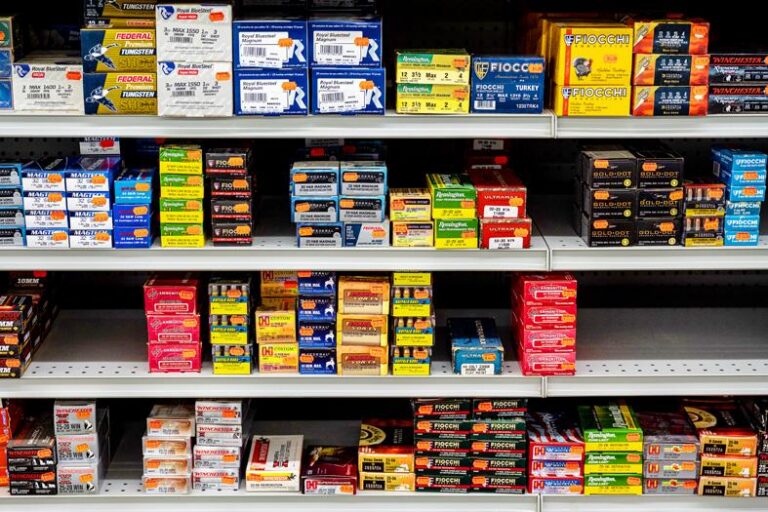 Boxed handgun ammunition on a counter beside clearly labeled cartridge packaging